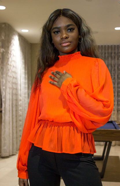 Oranged colored smocked neckline top with exaggerated sleeves